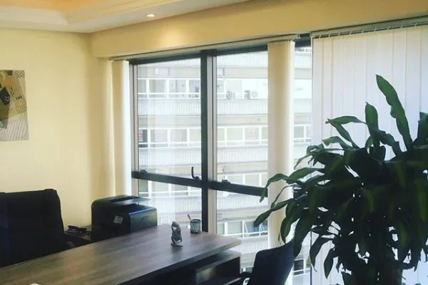 Escritório privativo do Endereço Fiscal em Florianópolis da LAWFFICE, com mesa de trabalho e janela ampla